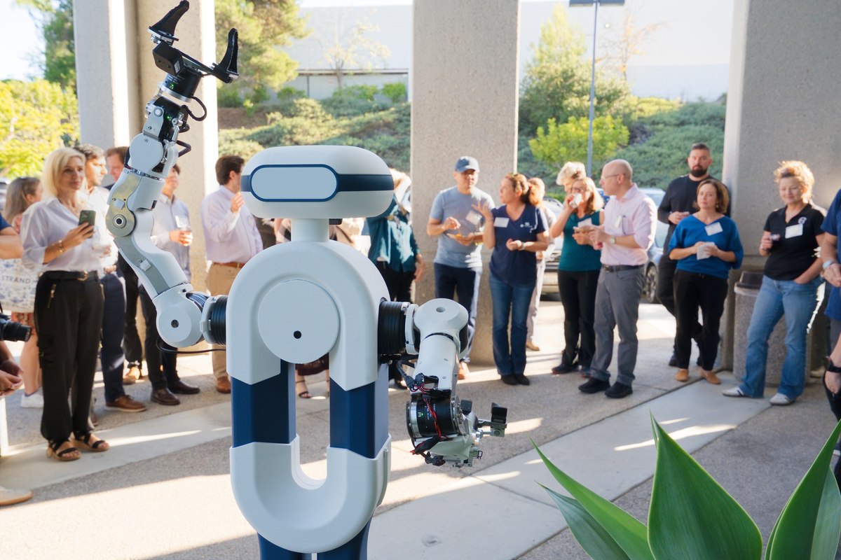 The Tactus AI humanoid robotic lab assistant raises an arm to a crowd of guests at the Tactus AI Open House in San Diego